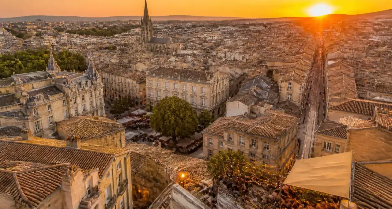 Vue aérienne de Montpellier au coucher du soleil, toits ocre et ciel rosé d'Occitanie